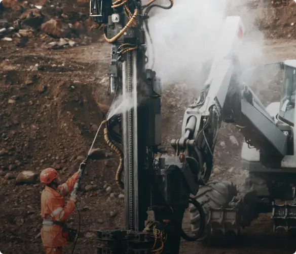 An operator standing with a drilling rig